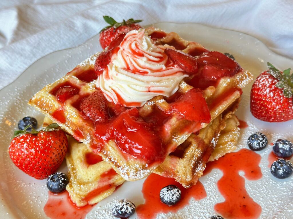 Strawberry compote with buttercream frosting topped waffles